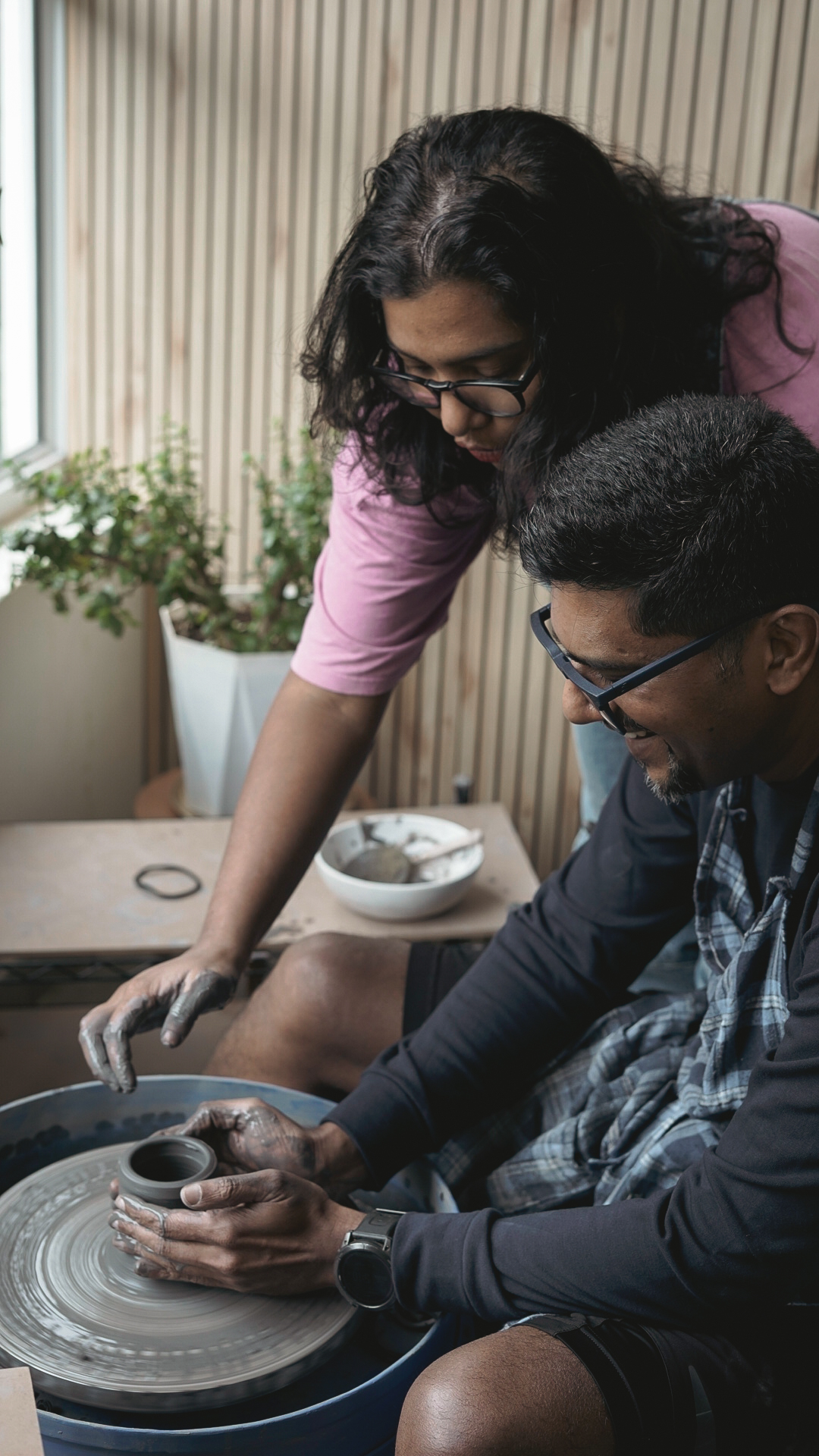Madhumita guiding a student at the pottery wheel